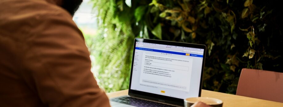 man in brown jacket looking at contract on DocuSign on a laptop