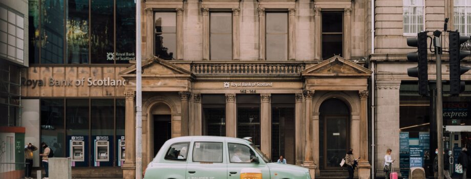 blue car parked in front of brown building